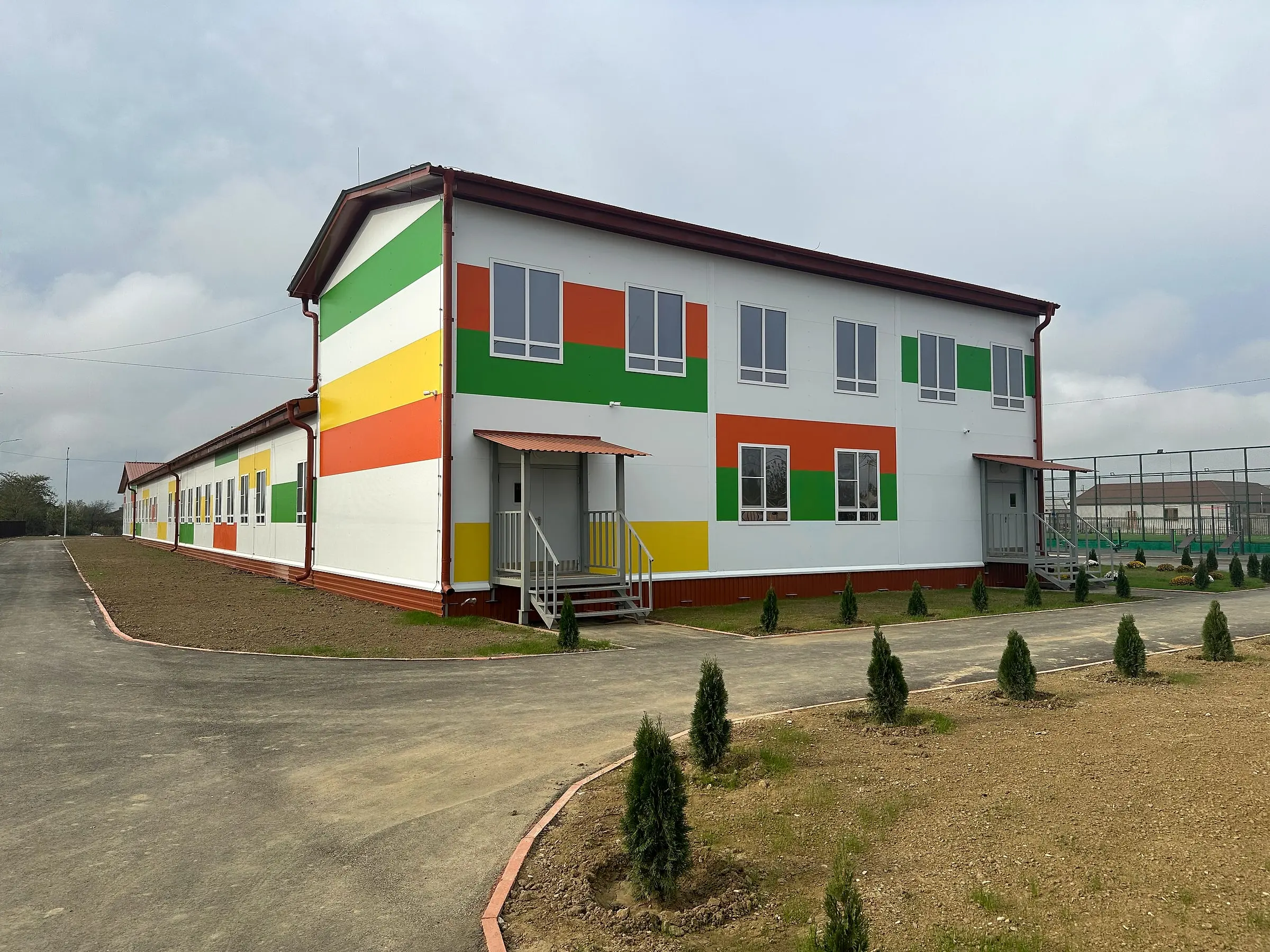 Новая школа: высокий блок спортзала в торце и длинное одноэтажное крыло